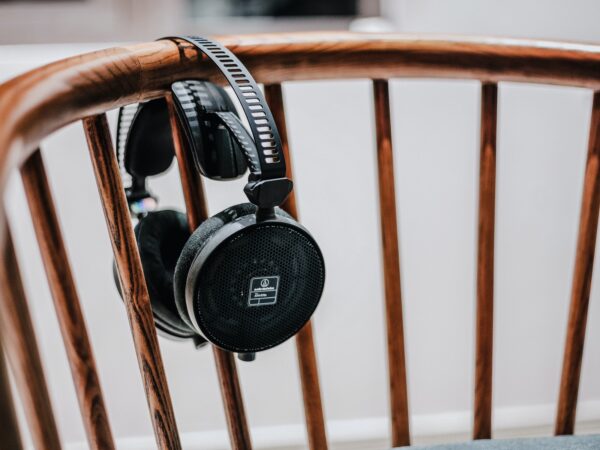 black cordless headphones on brown wooden chair